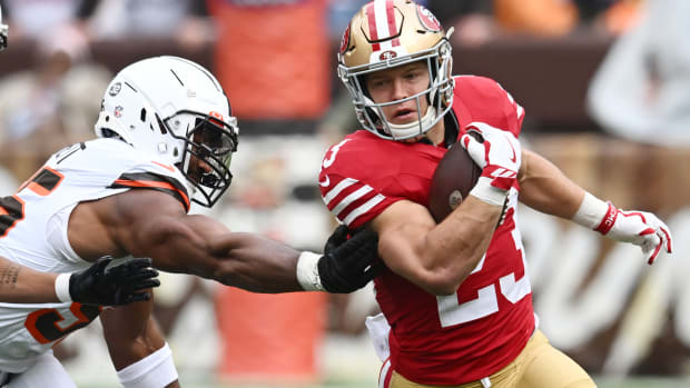 Oct 15, 2023; Cleveland, Ohio, USA; San Francisco 49ers running back Christian McCaffrey (23) runs from Cleveland Browns defensive end Myles Garrett (95) during the first half at Cleveland Browns Stadium. Mandatory Credit: Ken Blaze-USA TODAY Sports  